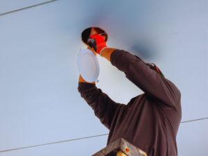 Electrician installing LED light fixture