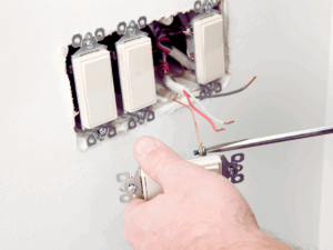 Electrician properly grounding light switches