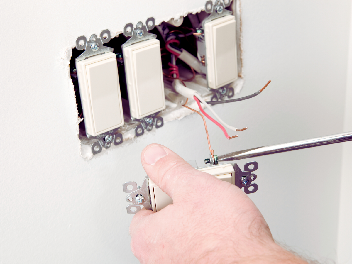 Electrician properly grounding light switches